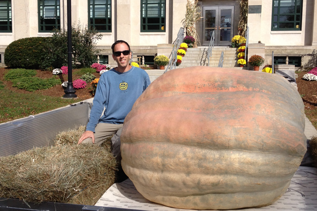 Smiling man sitting near a very large gourd